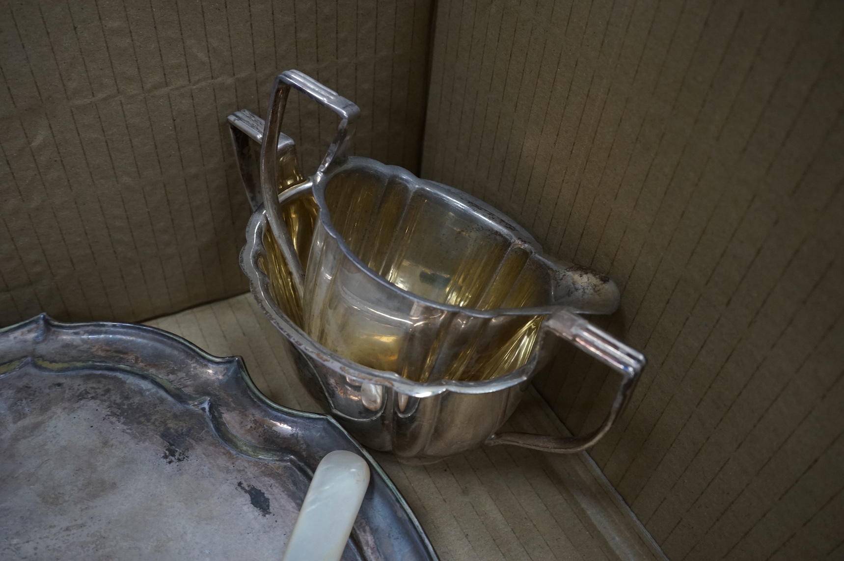 A group of assorted plated ware, including a pair of candlesticks, a salver, toast rack and cutlery including set of mother of pearl handled dessert eaters, together with a George V silver mounted trinket box and two sil